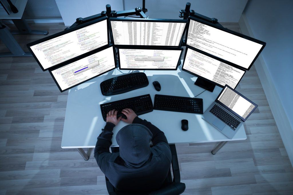 dark workspace with multiple screens for coding and data analysis.