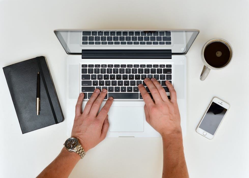 modern workspace with laptop, notebook, pen, smartphone, and coffee cup for productivity and creativity.