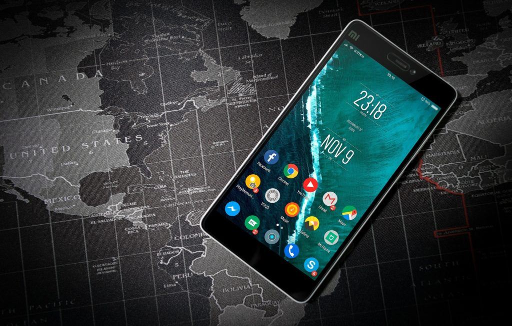 smartphone interface with date and time on world map background, symbolizing global connectivity.