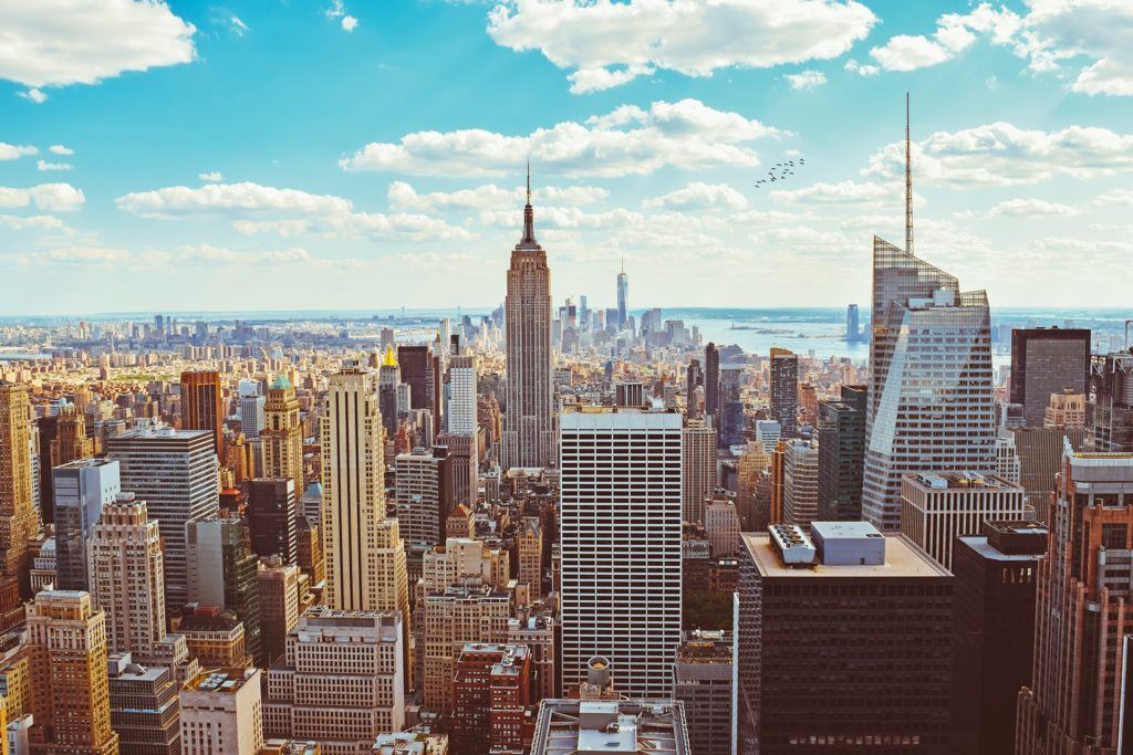 aerial view of iconic new york city skyline at dusk, showcasing architectural marvels under blue sky.