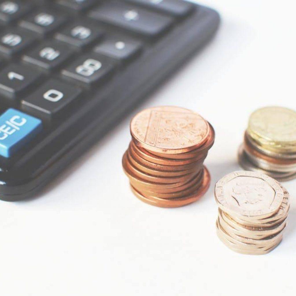 managing finances with calculator and coins for effective budgeting and planning.