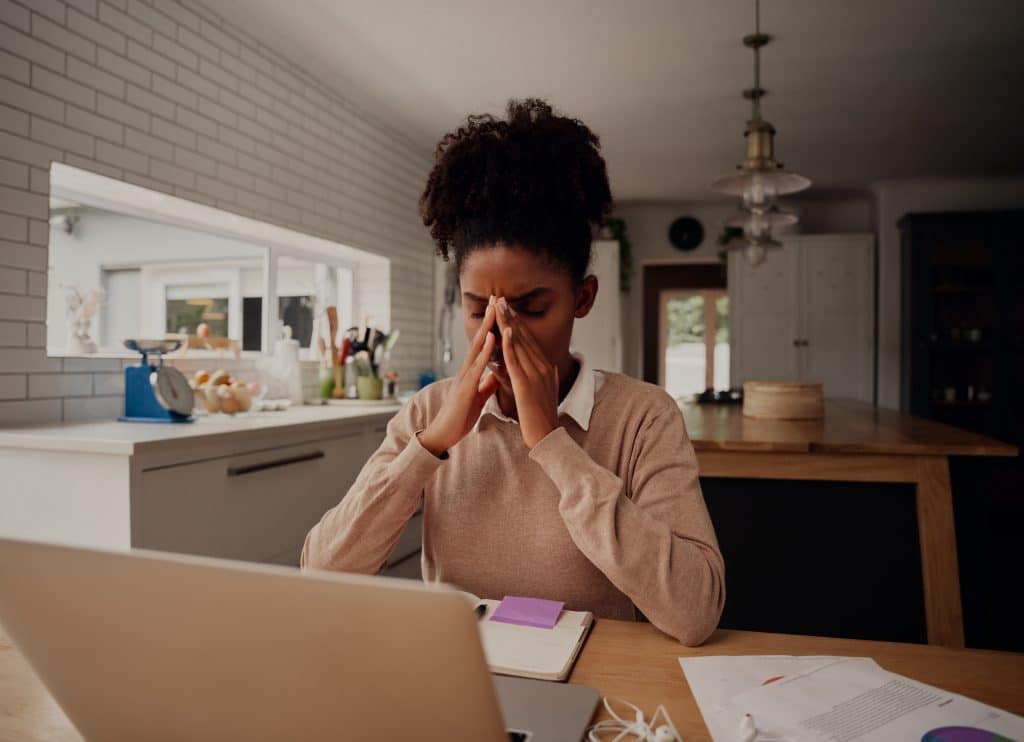 a woman sitting at a table in front of a laptop