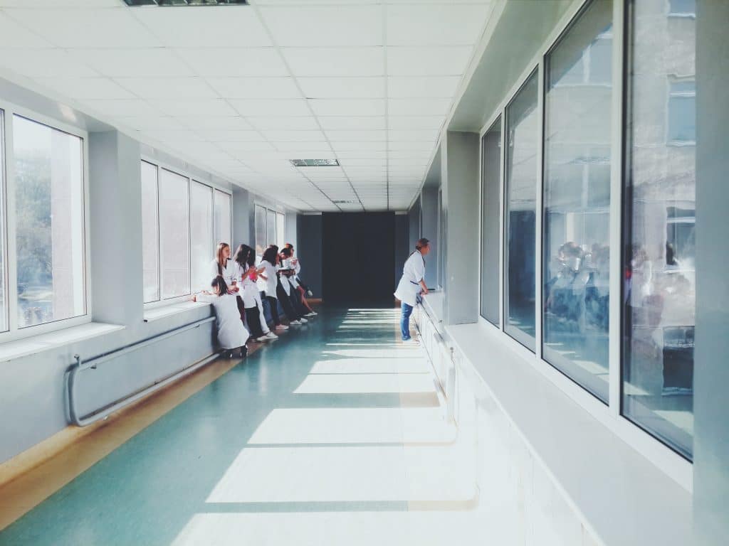 healthcare professionals collaborating in a bright hospital corridor filled with natural light.