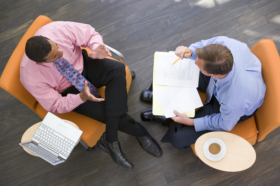 dynamic business discussion: two professionals engaged over coffee and laptop.