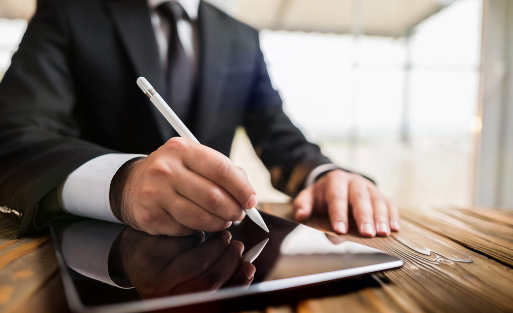 modern business productivity: professional in suit using stylus on sleek tablet for efficiency.