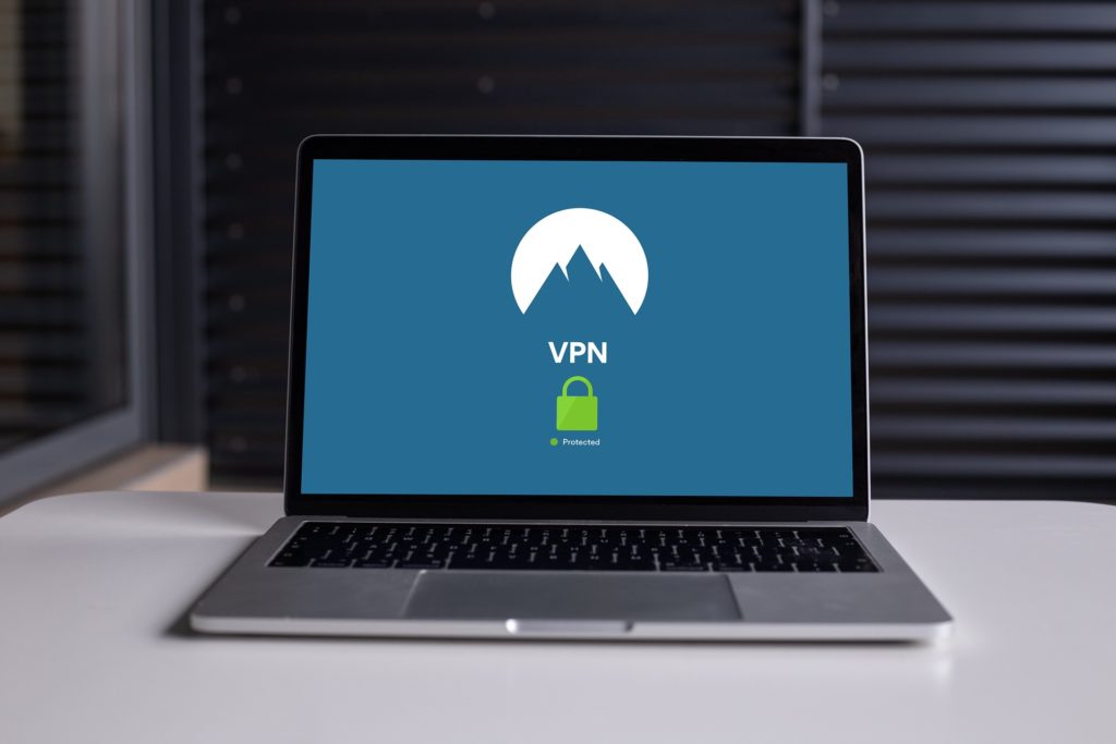 enhancing business security with sleek laptop displaying vpn logo in modern office setting.