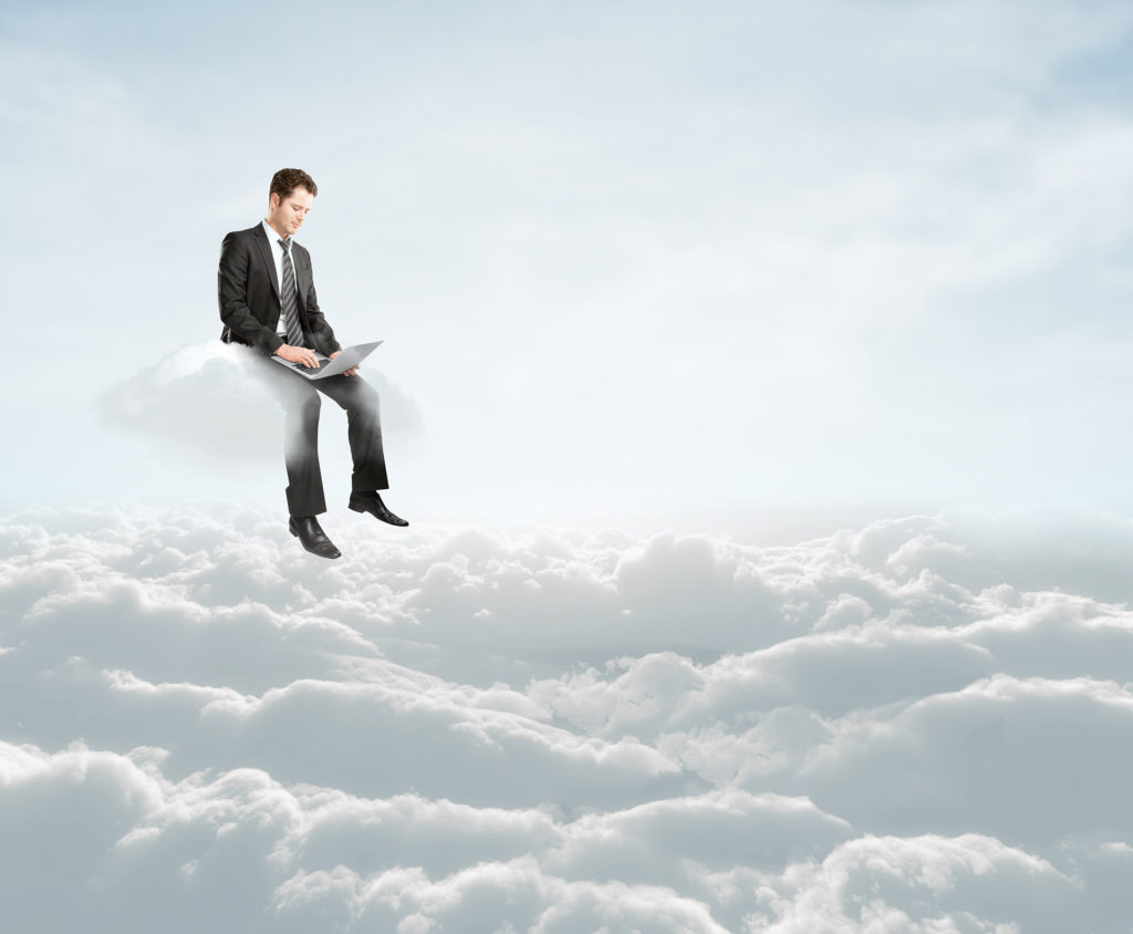 man in suit typing on cloud, symbolizing balance between work and dream in digital era.