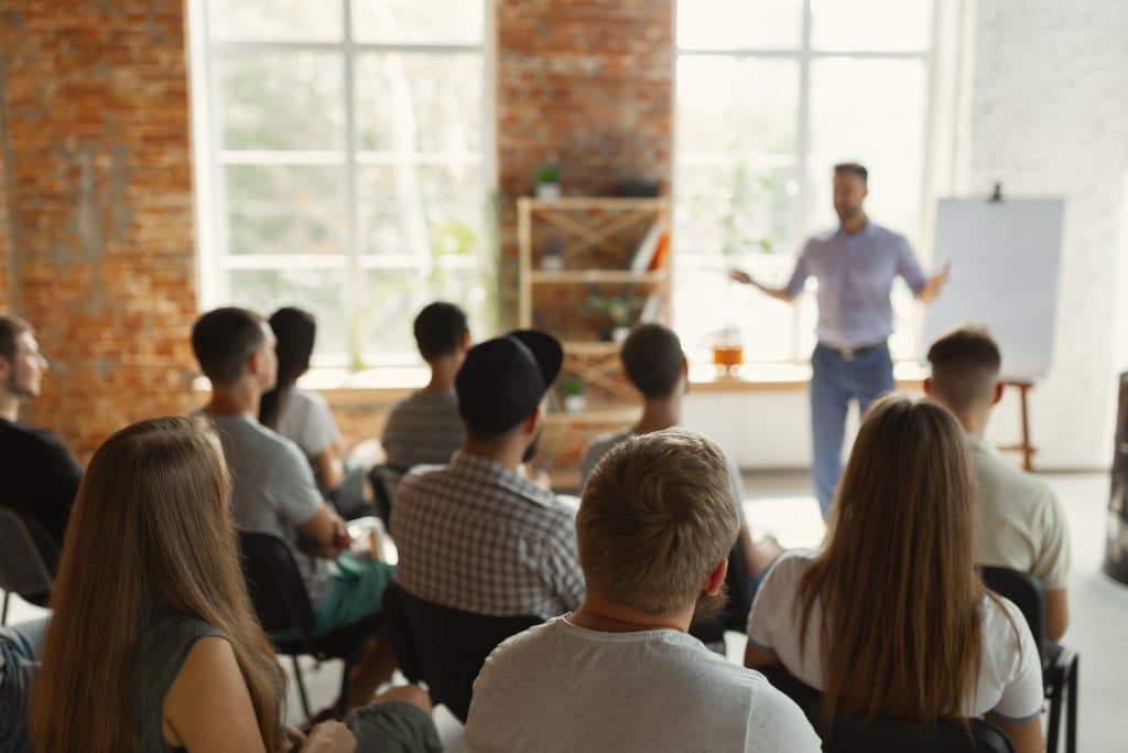 engaging workshop in rustic setting with diverse audience and dynamic presenter.