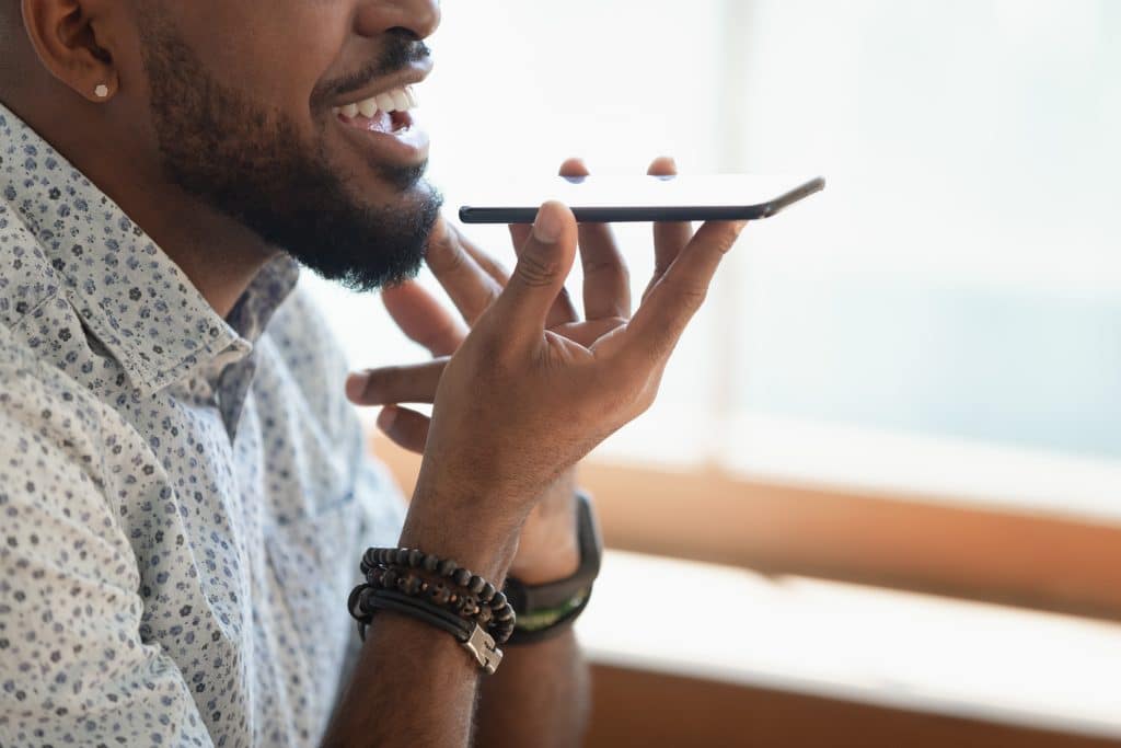 man chatting stylishly on smartphone in bright room.