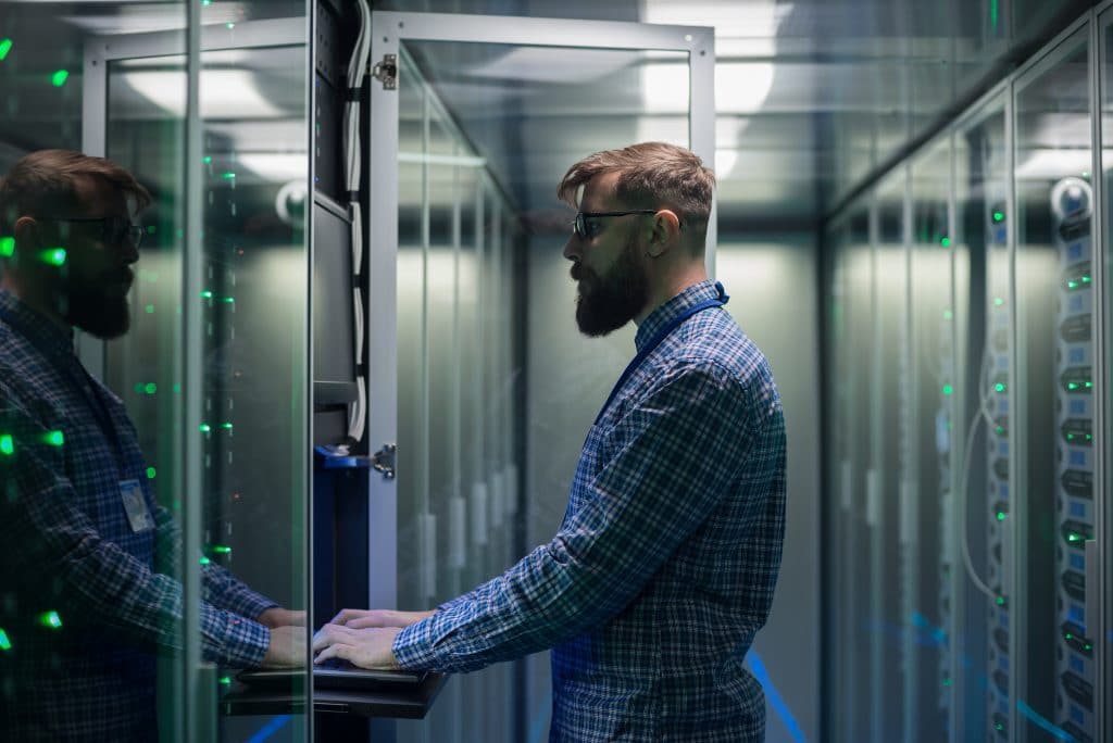 efficient technician managing data in advanced server room with glowing racks.