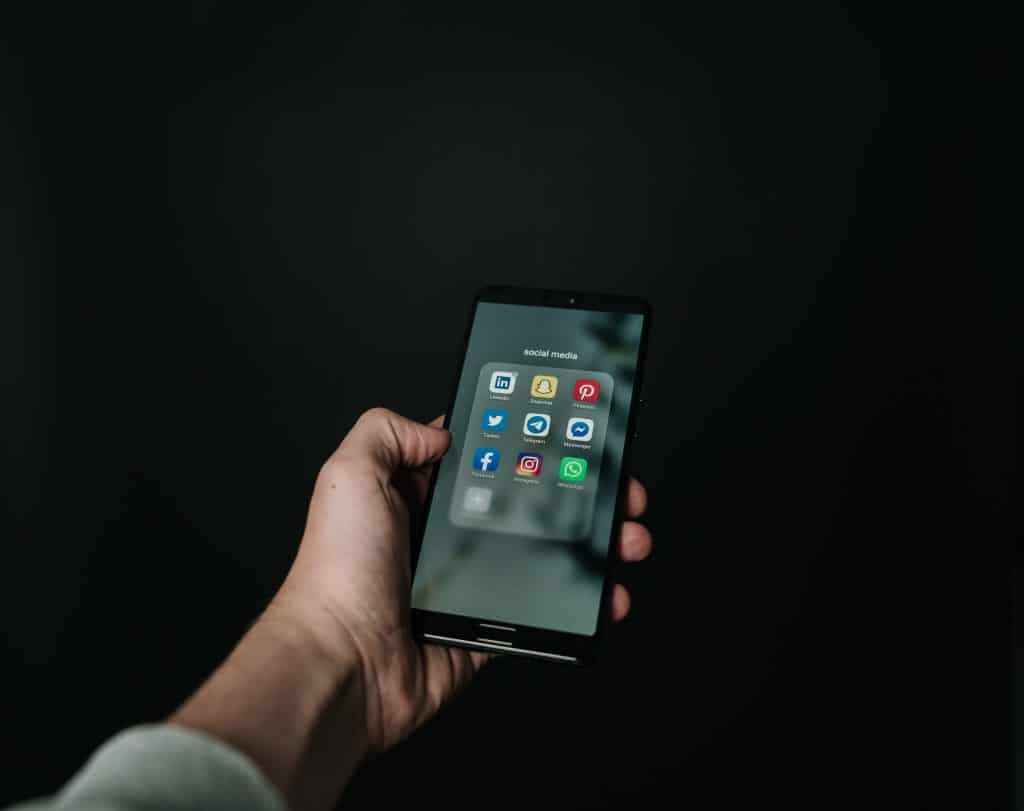 modern smartphone with vibrant social media icons against dark background, showcasing digital connectivity.