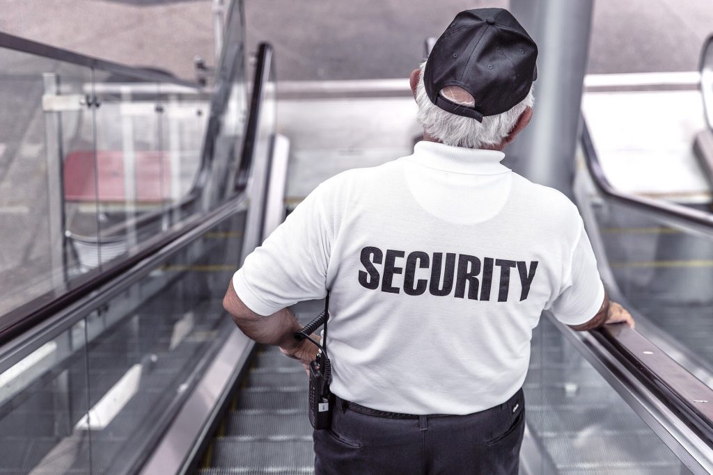 vigilant security guard on modern escalator in public space.