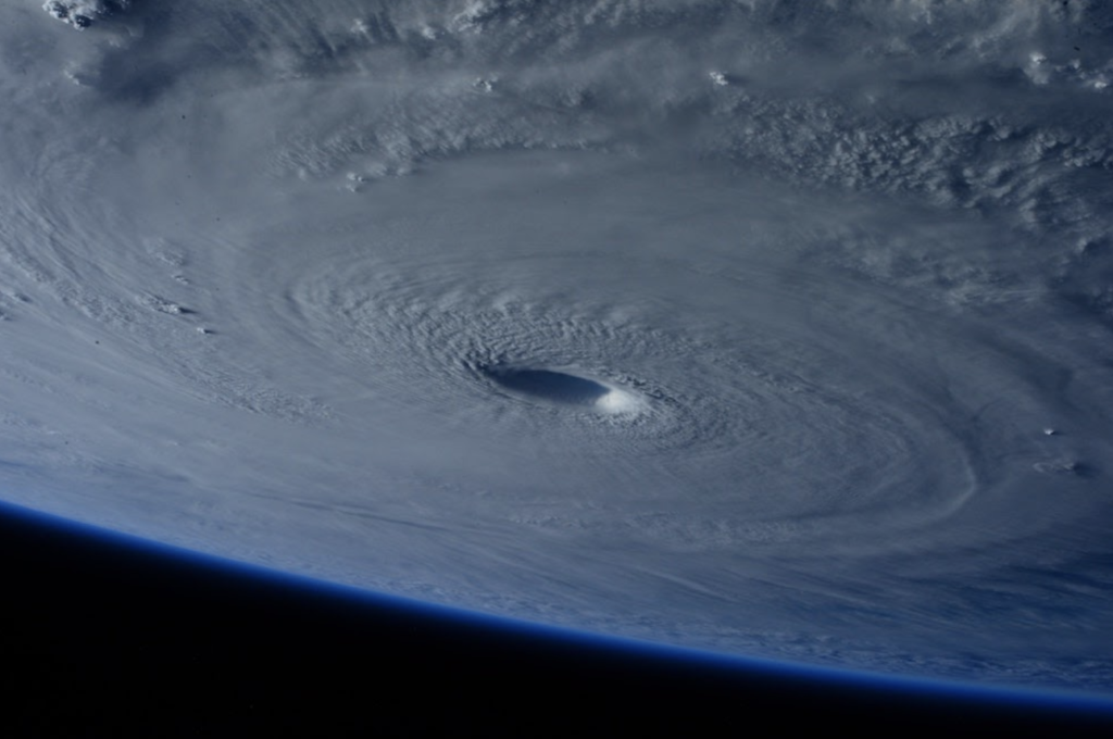 majestic hurricane spiral formation seen from space, showcasing powerful swirling clouds and calm eye.