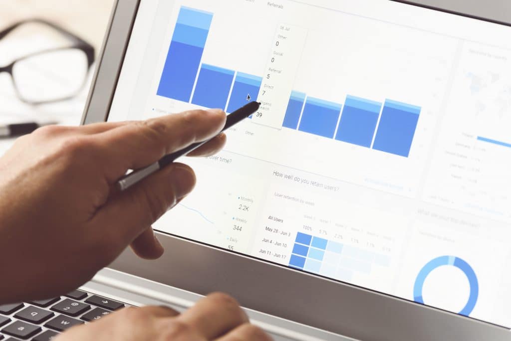 analyzing data trends with pen on laptop for professional decision-making.