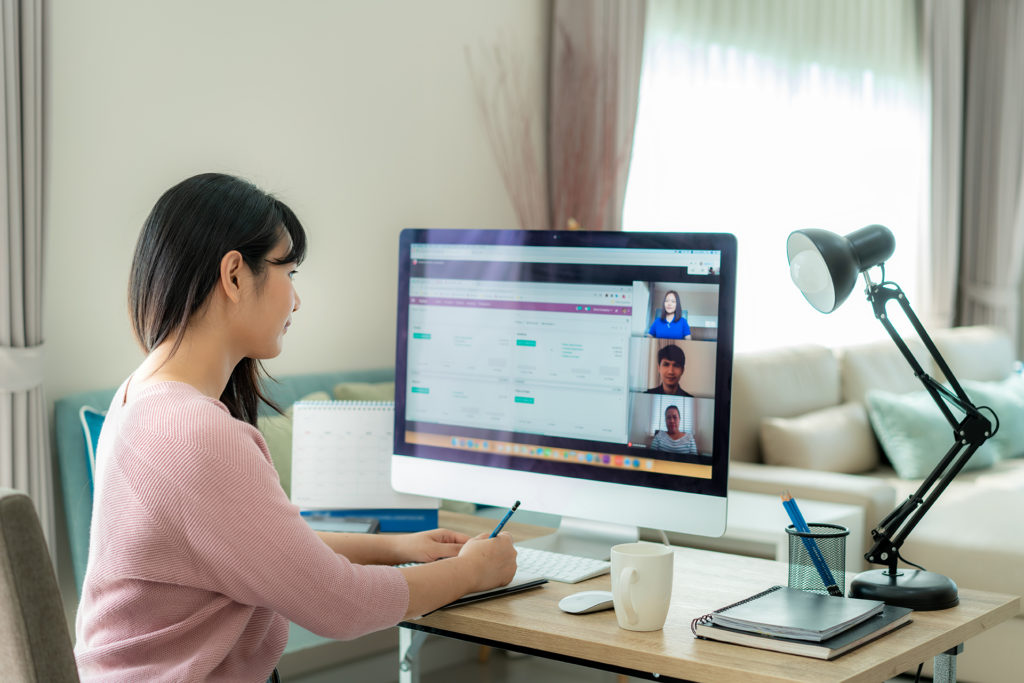 woman in modern home office attending virtual meeting, embracing remote work trend.