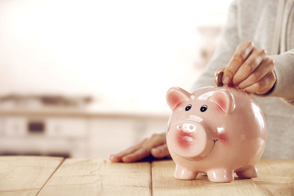 a person putting money into a piggy bank