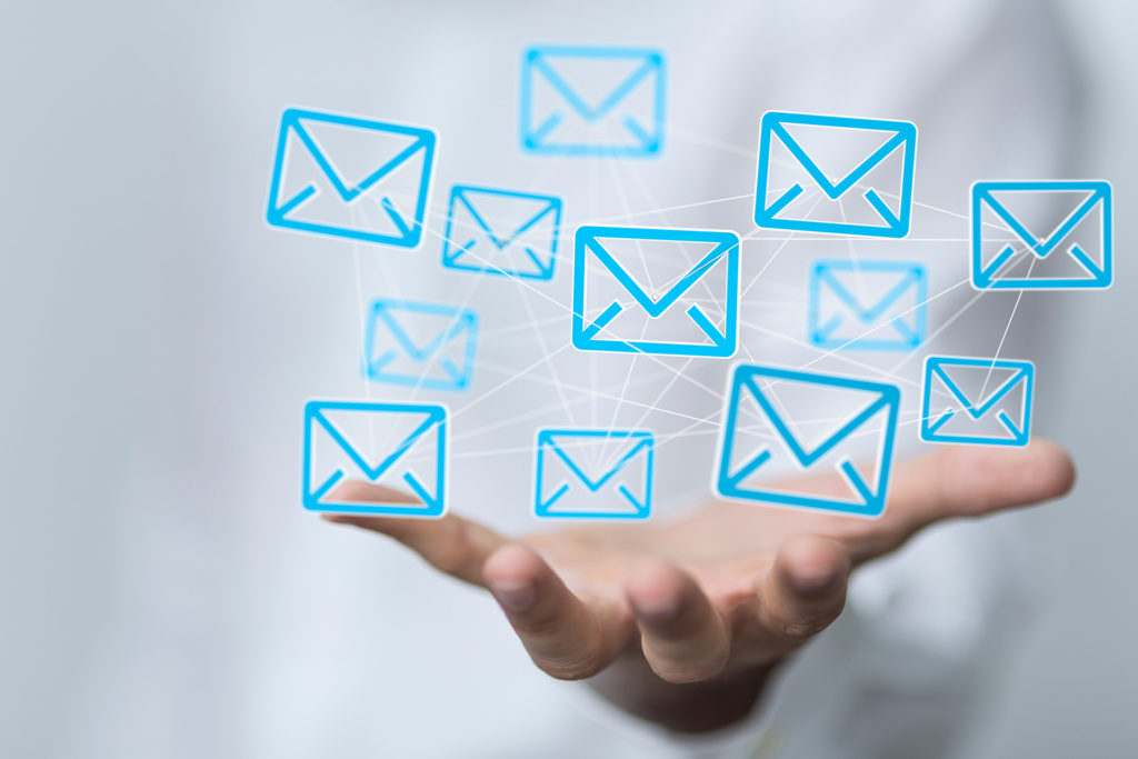 a person holding out their hand with email icons on it