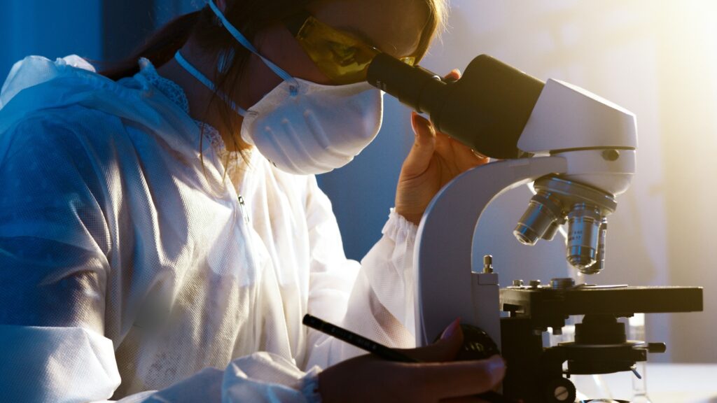 dedicated scientist analyzing specimen with modern microscope in well-lit lab.