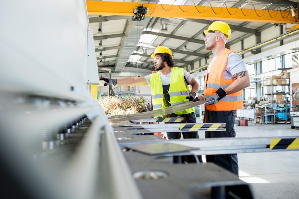 metal fabrication teamwork in industrial setting: two skilled workers collaborate efficiently with machinery.