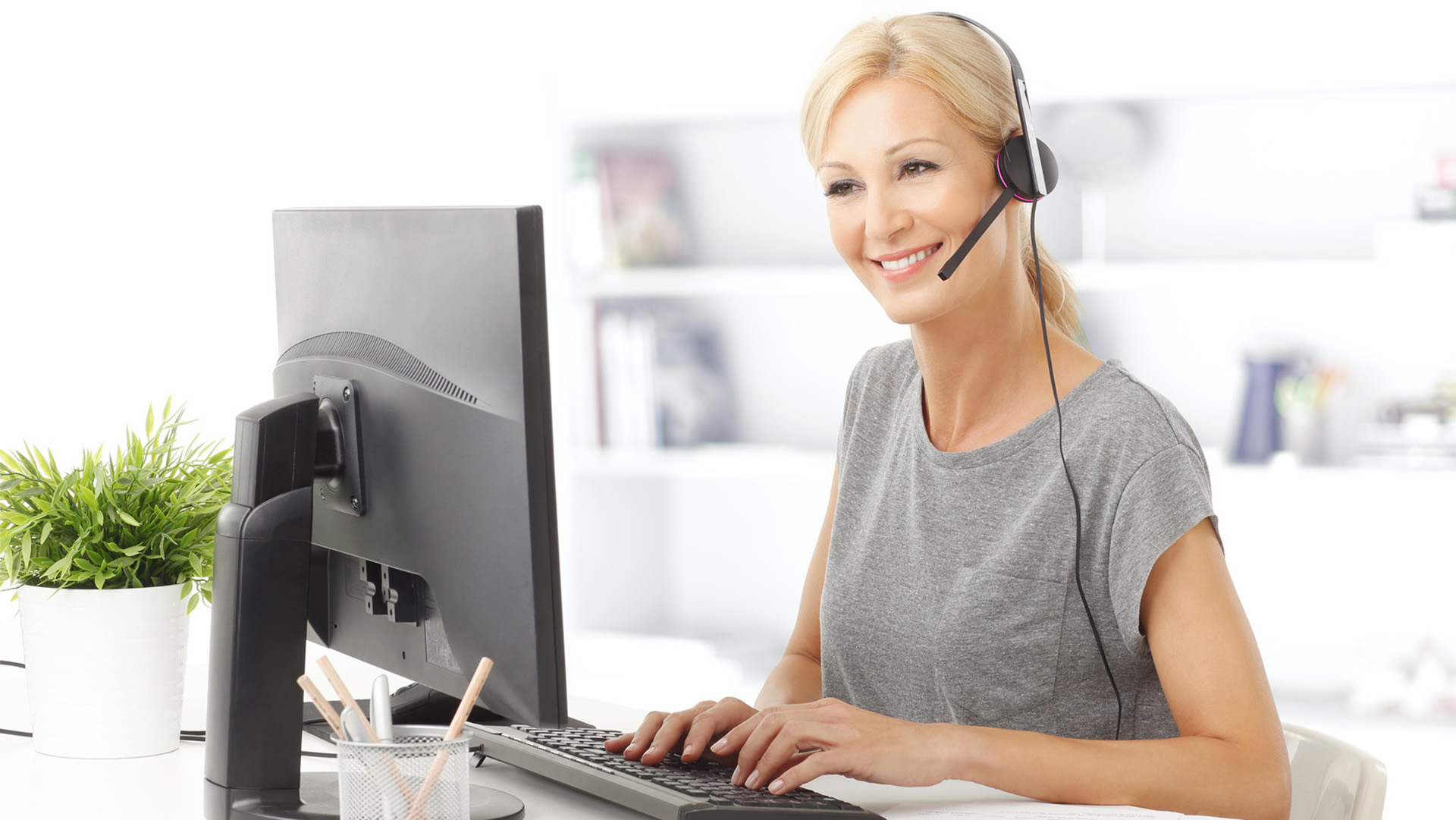 a woman wearing a headset and using a computer