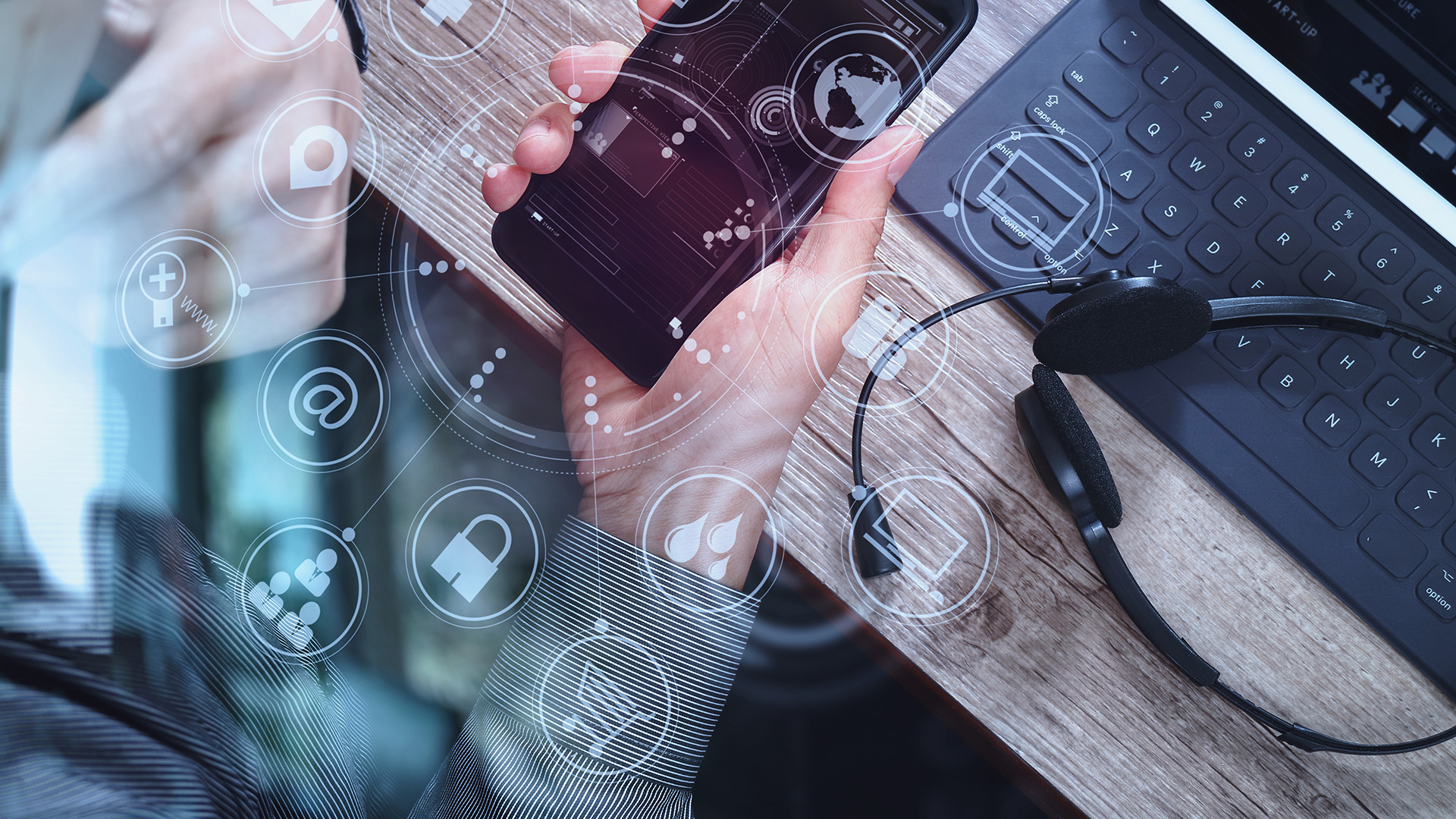 top-down view of man using voip headset and tablet in modern office setting.