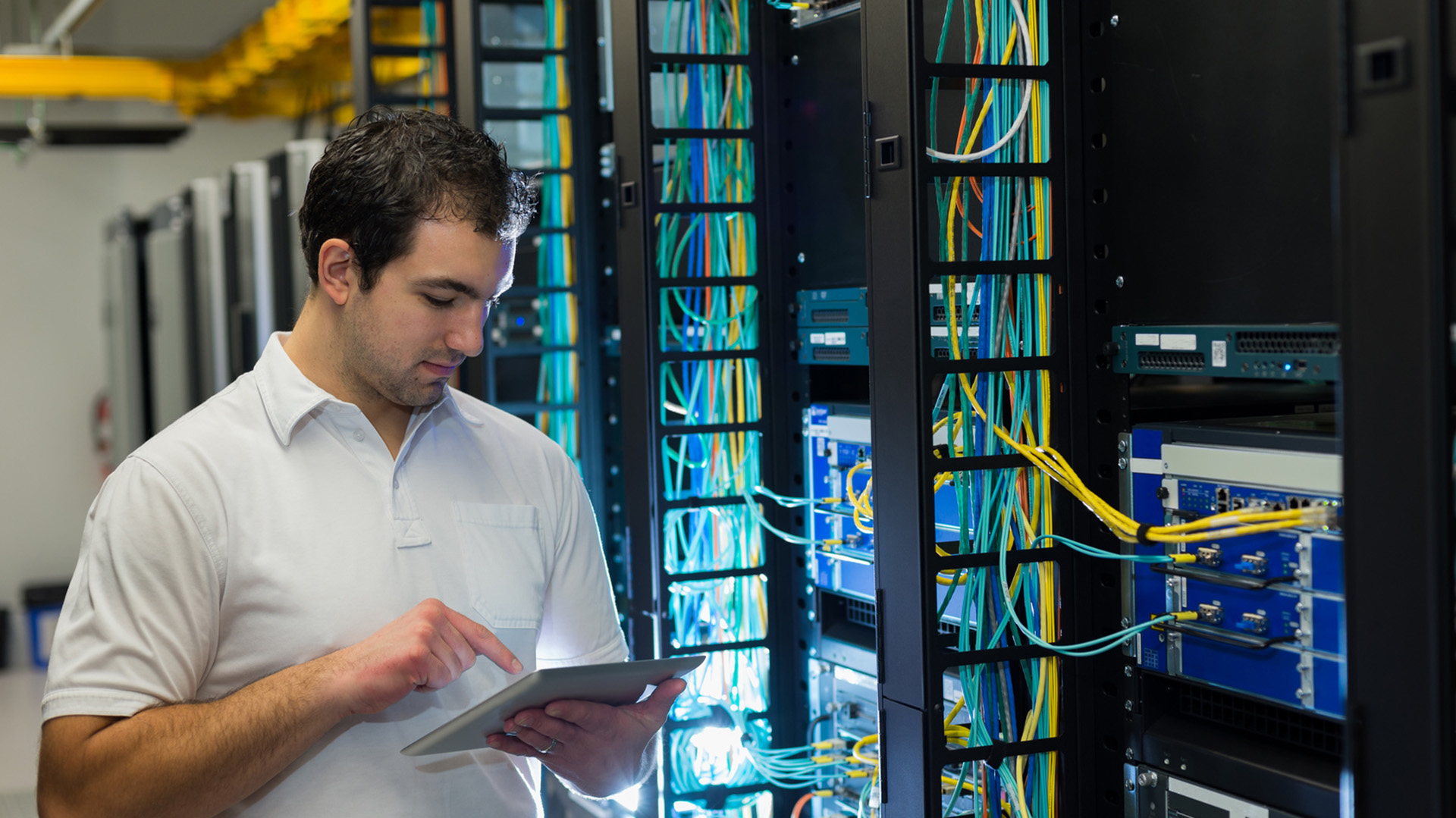 a man standing in front of a server holding a tablet