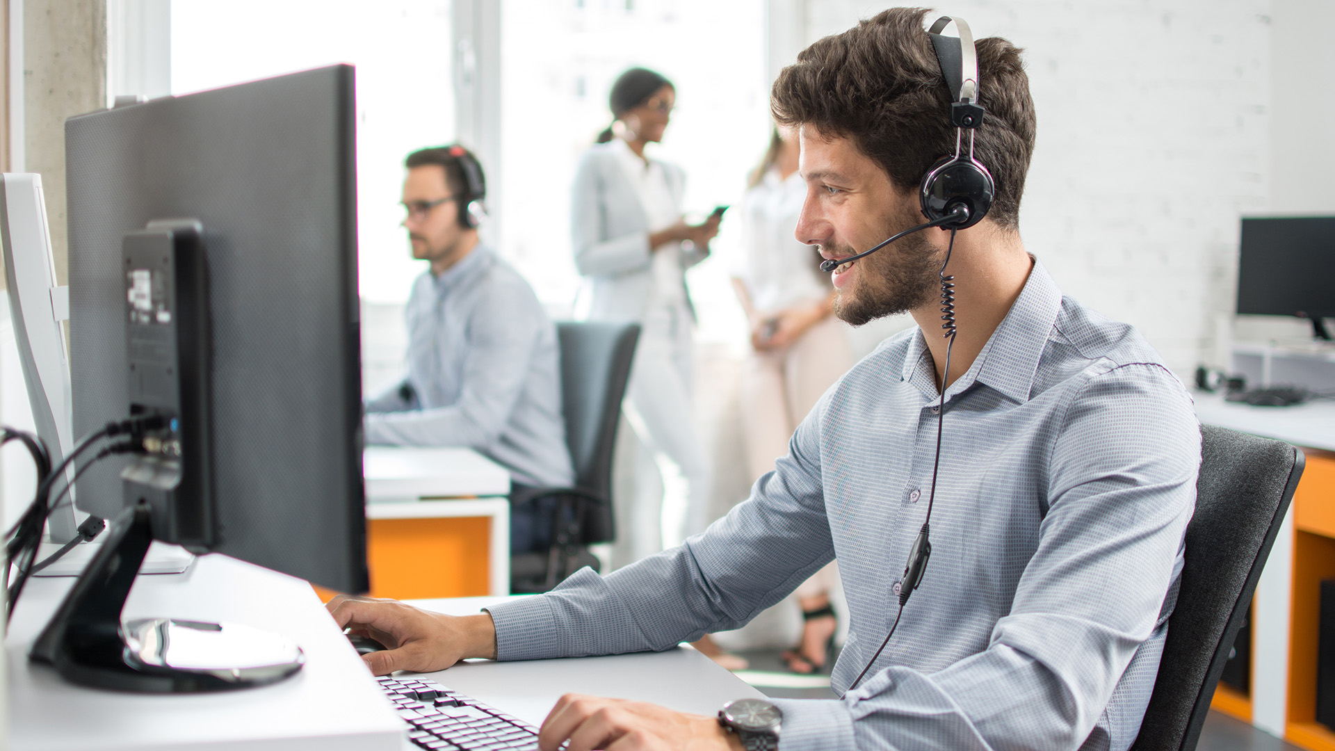 a man sitting at a computer with headphones on