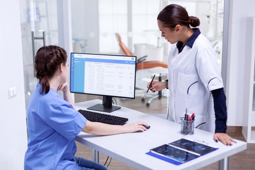 dentist and nurse discussing patient appointments in modern dental office.