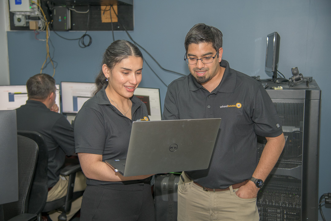 tech professionals collaborating in a modern office workspace with laptops and teamwork.