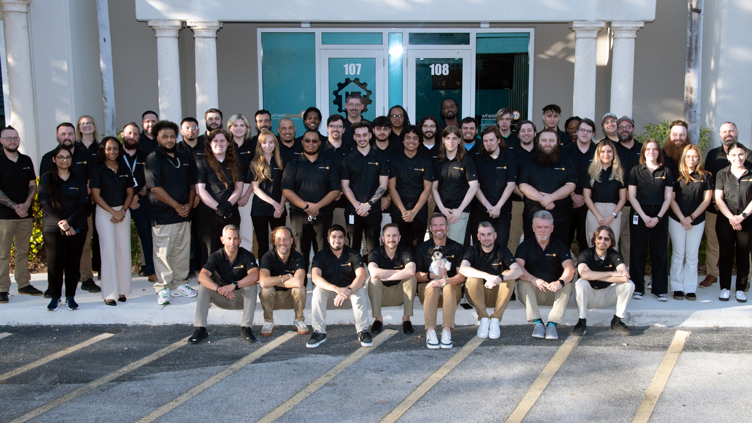 diverse team of professionals gathered outside a modern office building.