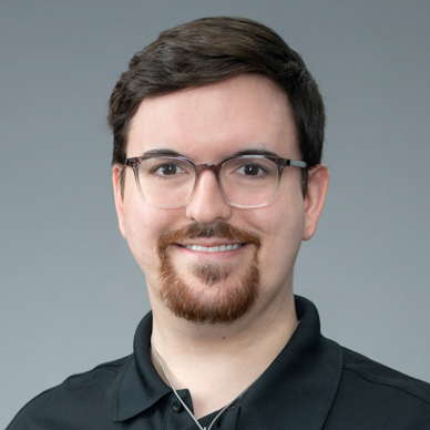 young man with friendly smile in black shirt and glasses, exuding approachable professionalism.