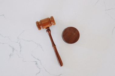 wooden gavel resting on marble base symbolizing authority and order in legal setting.