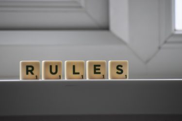 the word rules spelled with scrabble tiles